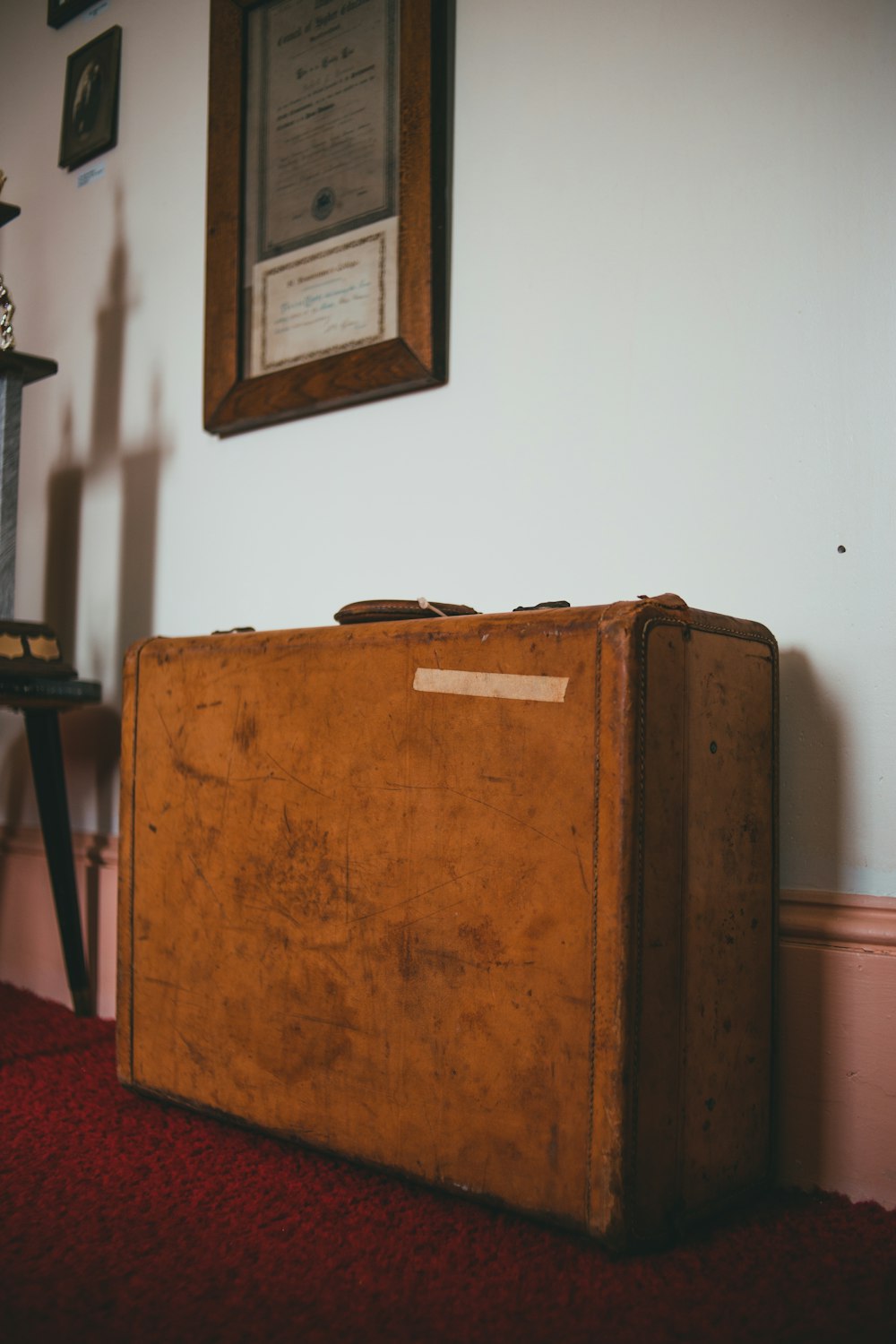 brown wooden box beside white wall