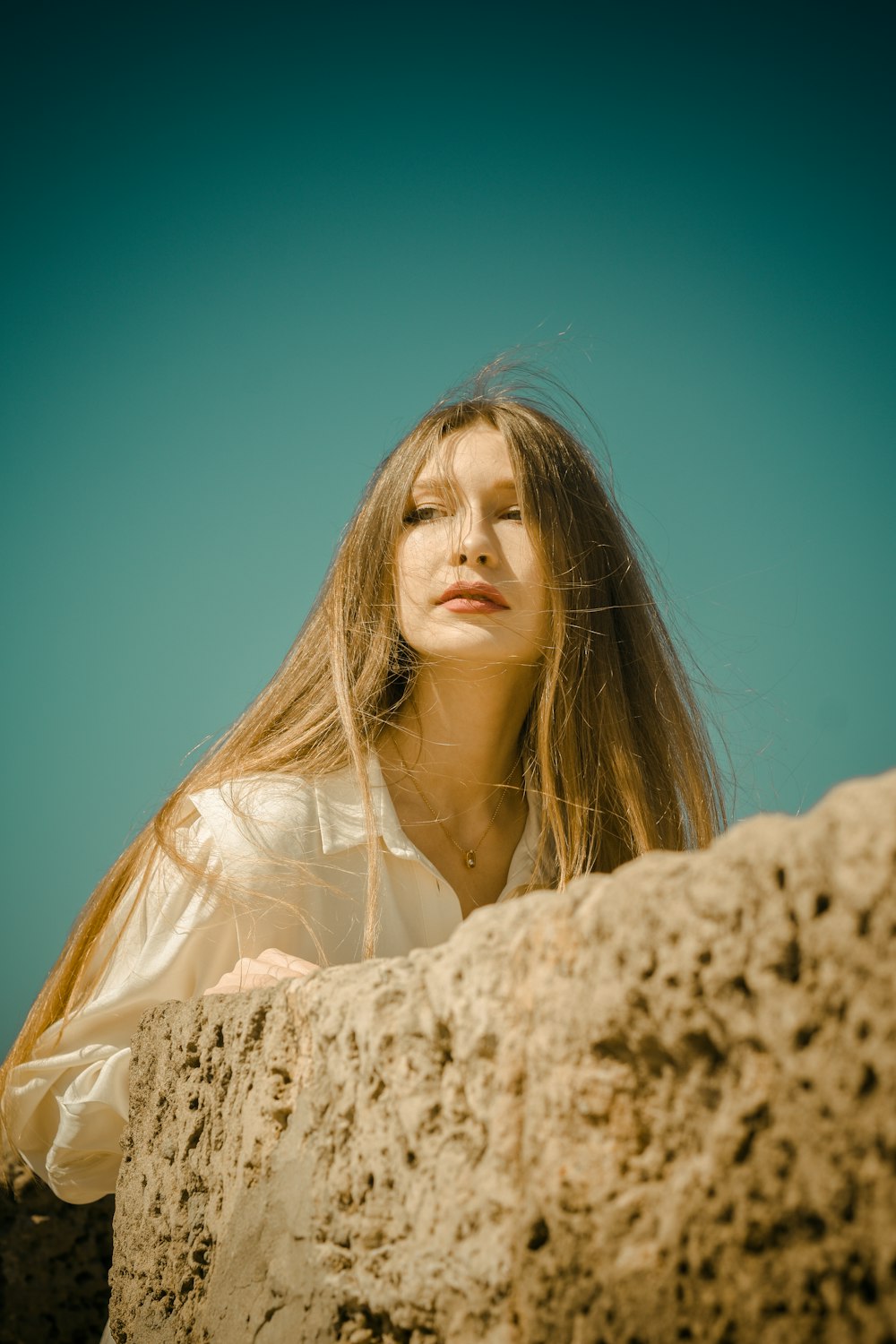 woman in white dress standing on white rock during daytime