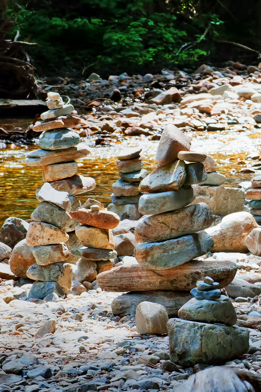 stack of stones near body of water during daytime