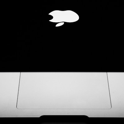 silver macbook on black surface