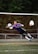 Action shot of a female goalkeeper diving to make a save wearing Yaseen Enterprises gloves.