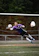 Goalkeeper making a diving save on a rainy soccer field, gloves gripping the ball tightly.