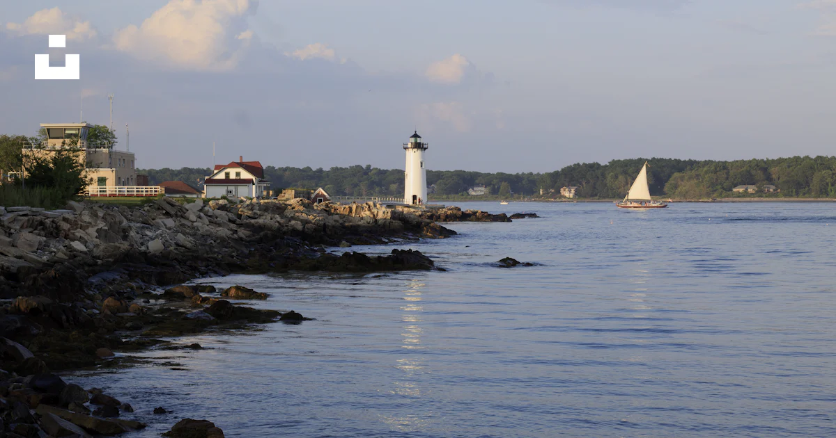 White lighthouse on rocky shore during daytime photo – Free Great ...