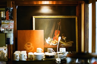 A cozy corner displaying vintage photographs and cultural artifacts inside cups n comfort.