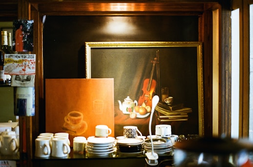 A cozy corner displaying vintage photographs and cultural artifacts inside cups n comfort.