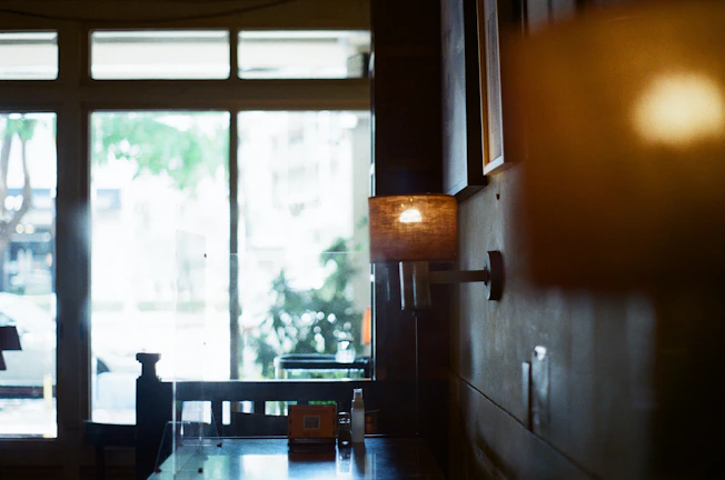 Softly lit café corner with warm wooden tables and gentle shadows.