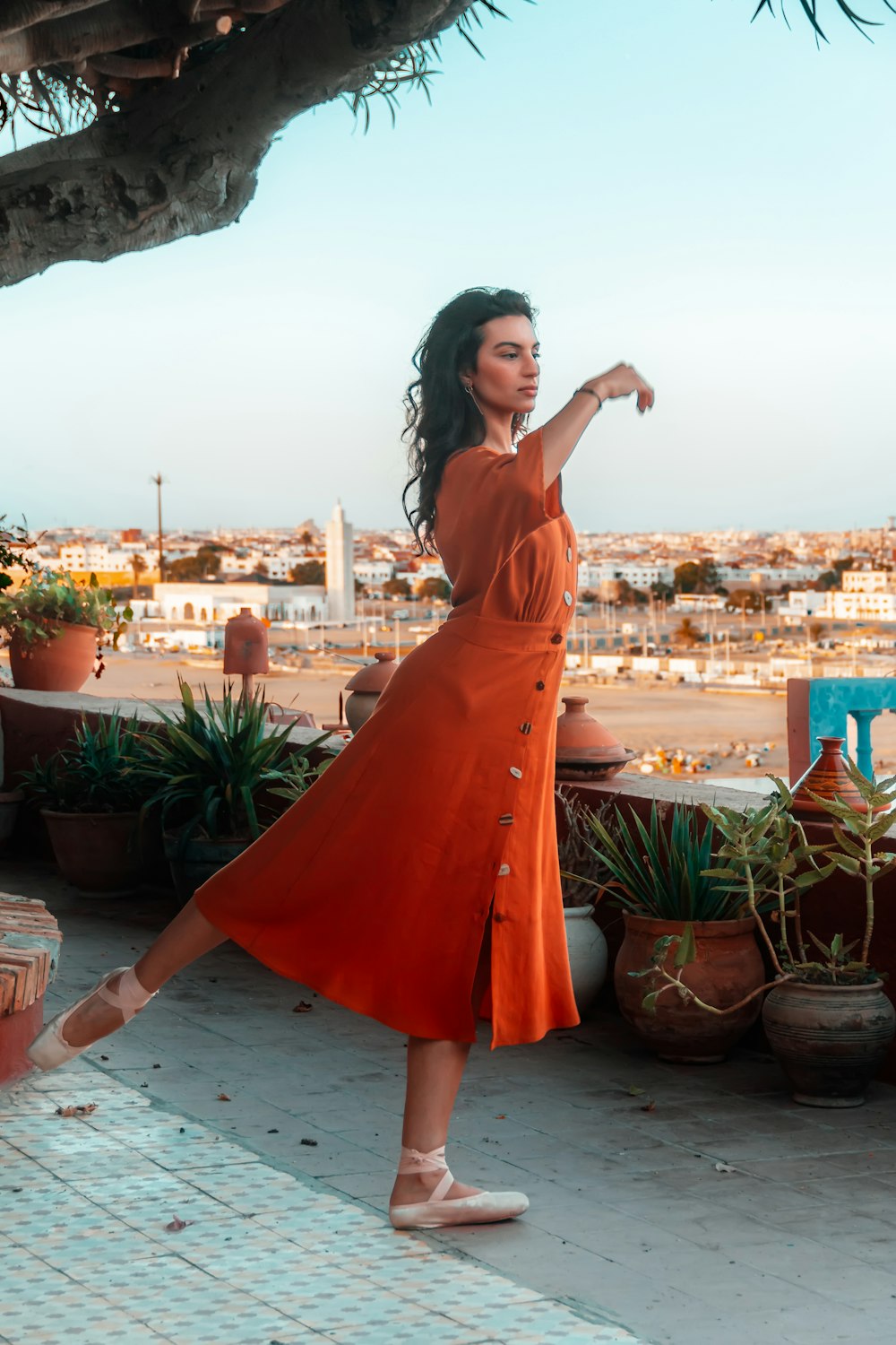 woman in orange dress standing on white floor during daytime