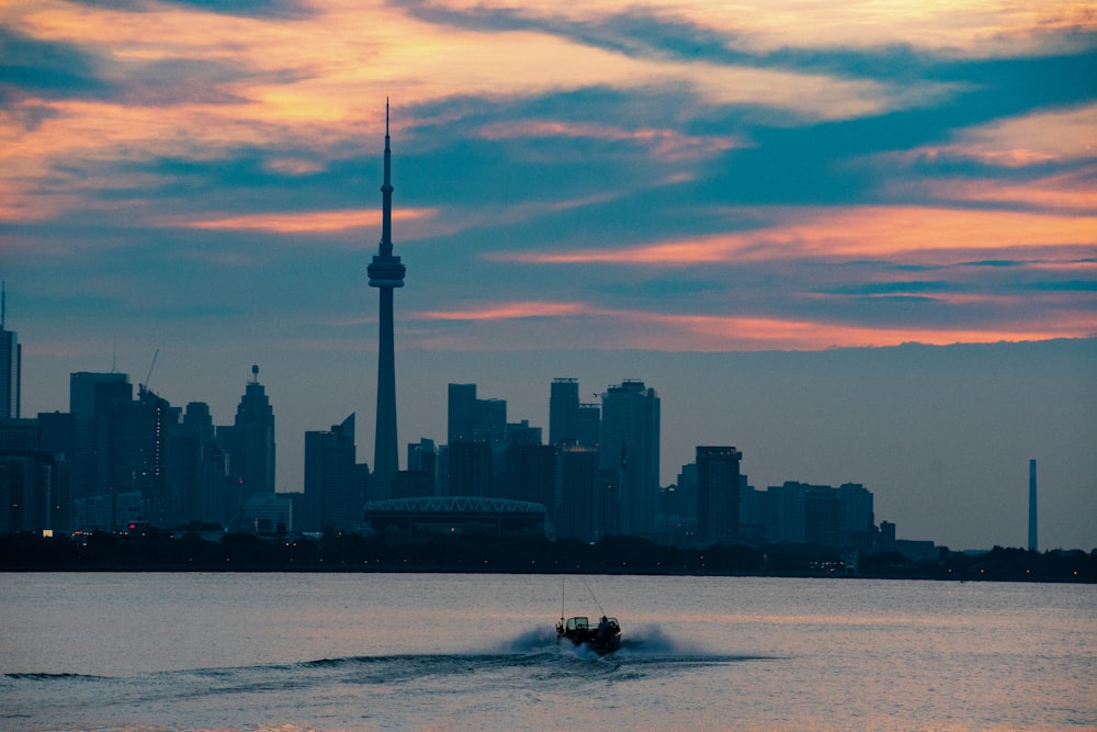 silhouette of man riding on boat on sea during sunset