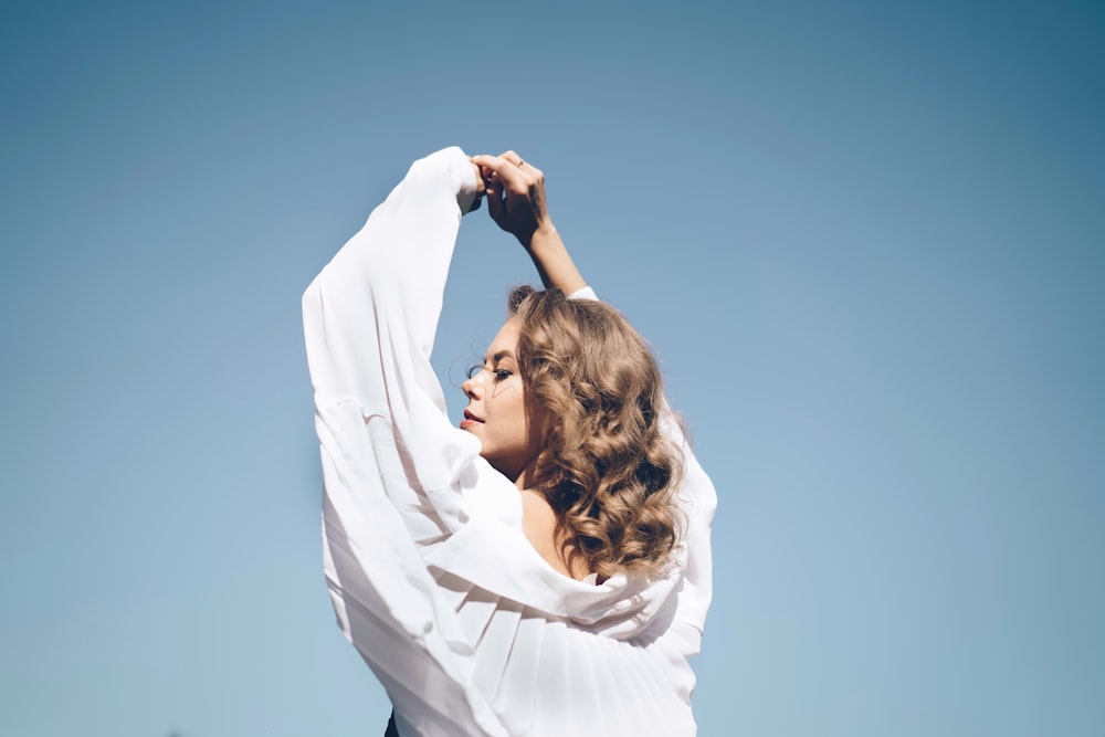 woman in white long sleeve shirt covering her face with white textile