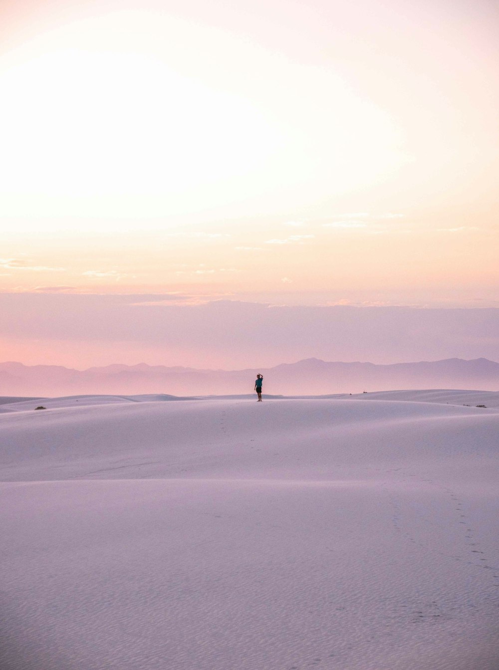 person walking on white sand during daytime