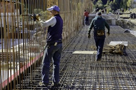 Construction workers building a sturdy concrete structure on site.