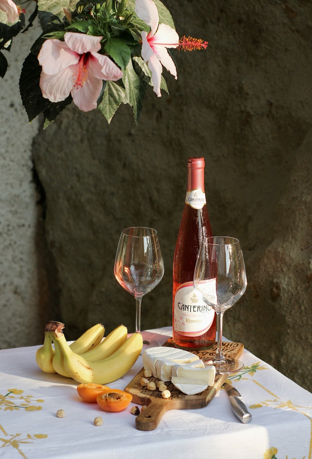 frutta gialla della banana accanto alla bottiglia di vino rosso