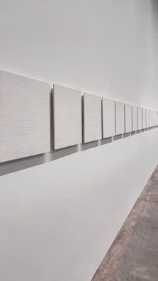 Horizontal line of Vertan Lab framed artworks arranged neatly with ample white space in a bright room.