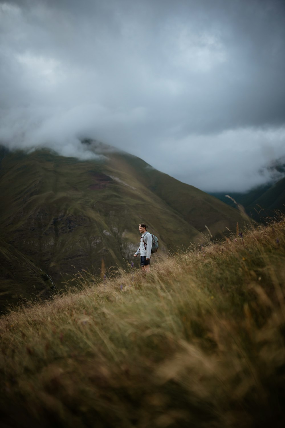 man in white jacket walking on green grass field during daytime