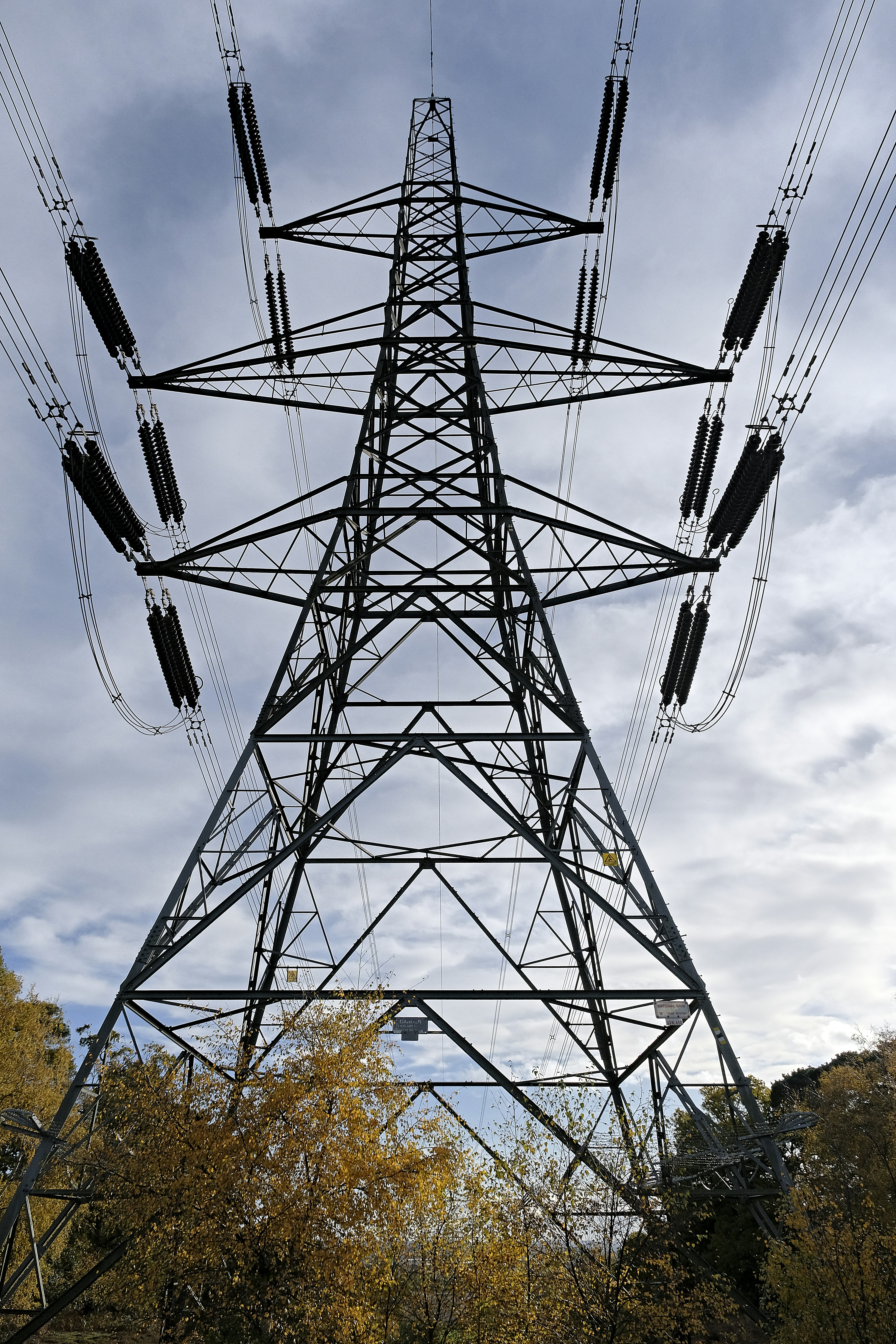 black metal electric tower under gray cloudy sky
