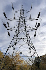 black metal electric tower under gray cloudy sky