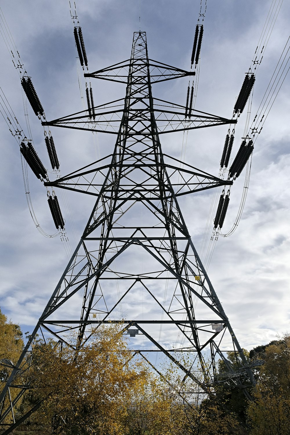 black metal electric tower under gray cloudy sky