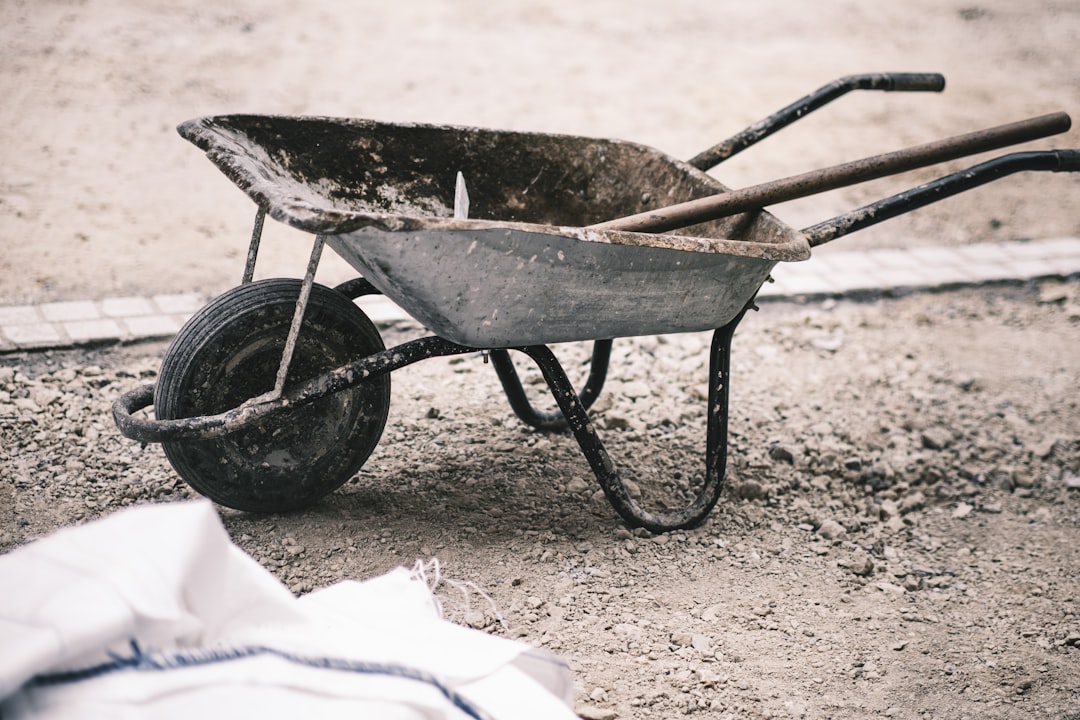 black and brown wheelbarrow on brown sand