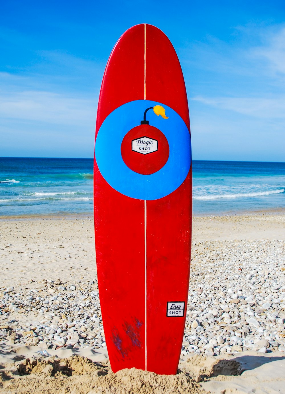 Rotes Surfbrett am Strandufer tagsüber