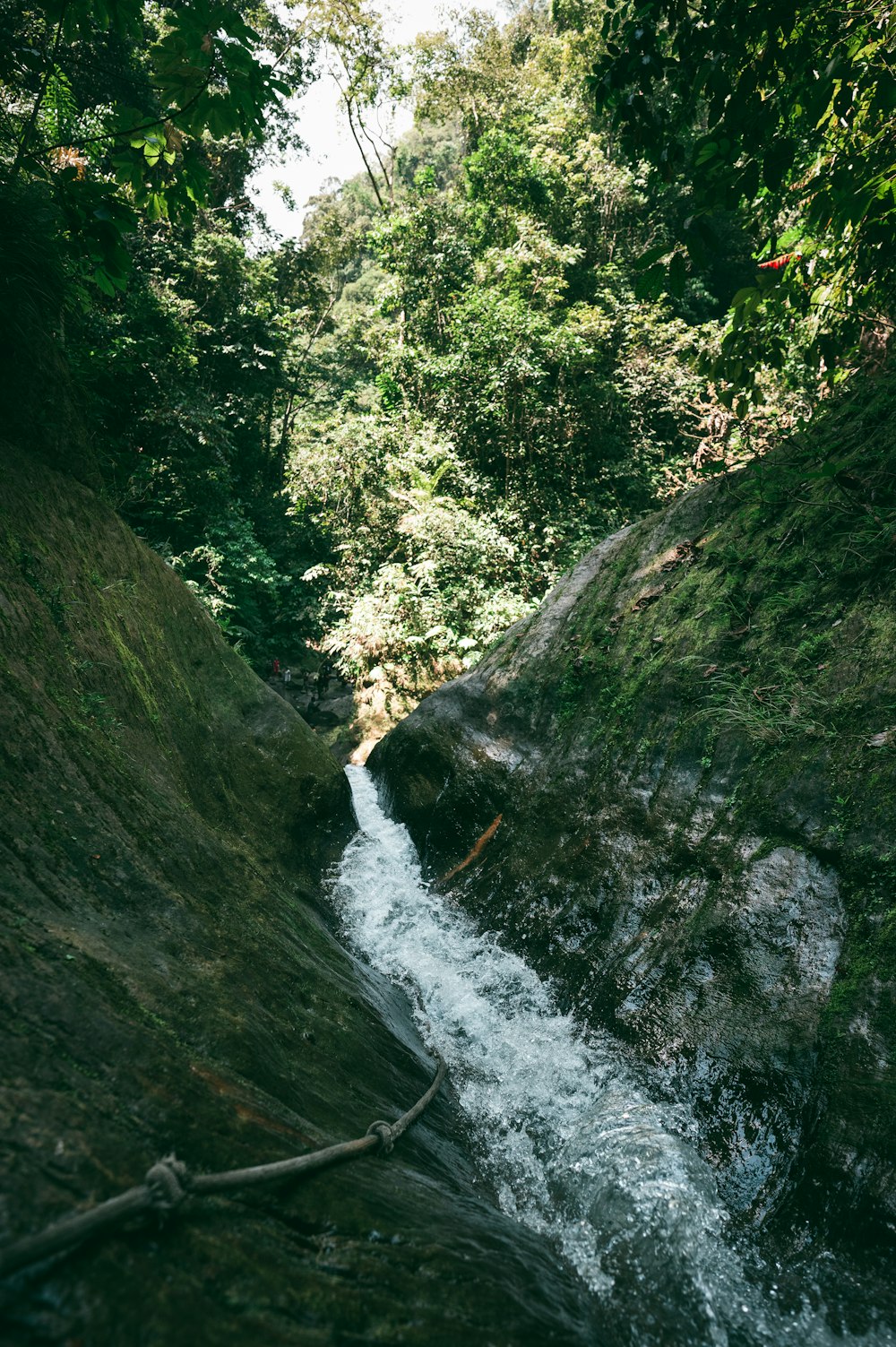 river in between green grass covered mountain during daytime