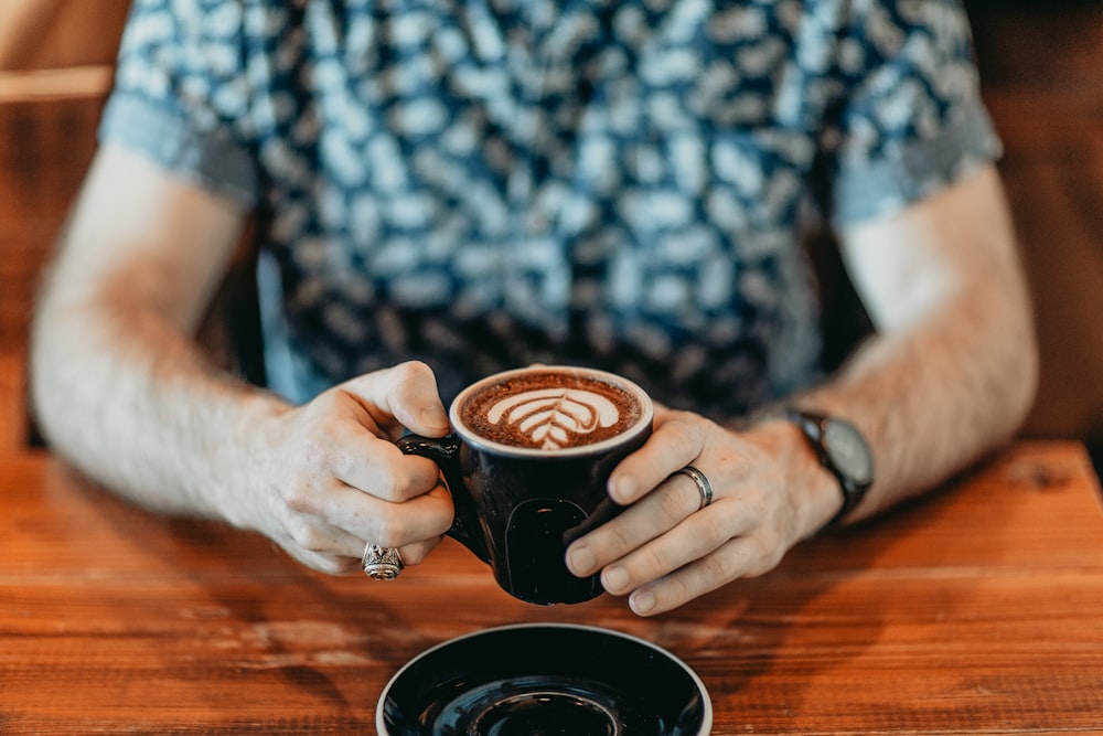 person holding black ceramic mug