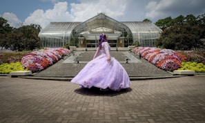 woman in pink dress standing on gray concrete floor