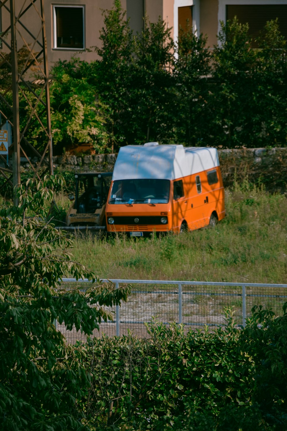 orange and white van on green grass field during daytime