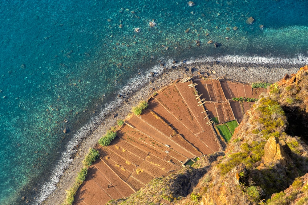 Vue aérienne d’un champ d’herbe verte près d’un plan d’eau pendant la journée