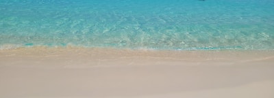Crystal-clear turquoise waters lapping against a pristine sandy beach.