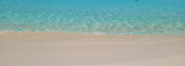 Crystal-clear turquoise waters gently lapping against a pristine white sandy beach.