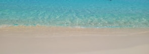 Crystal-clear turquoise waters gently lapping against white sandy shores.