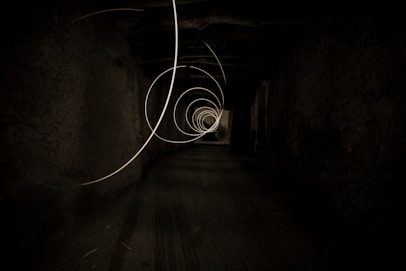 grayscale photo of tunnel with light