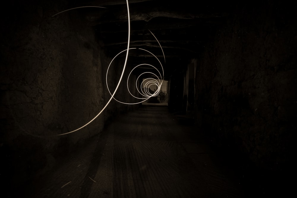 grayscale photo of tunnel with light
