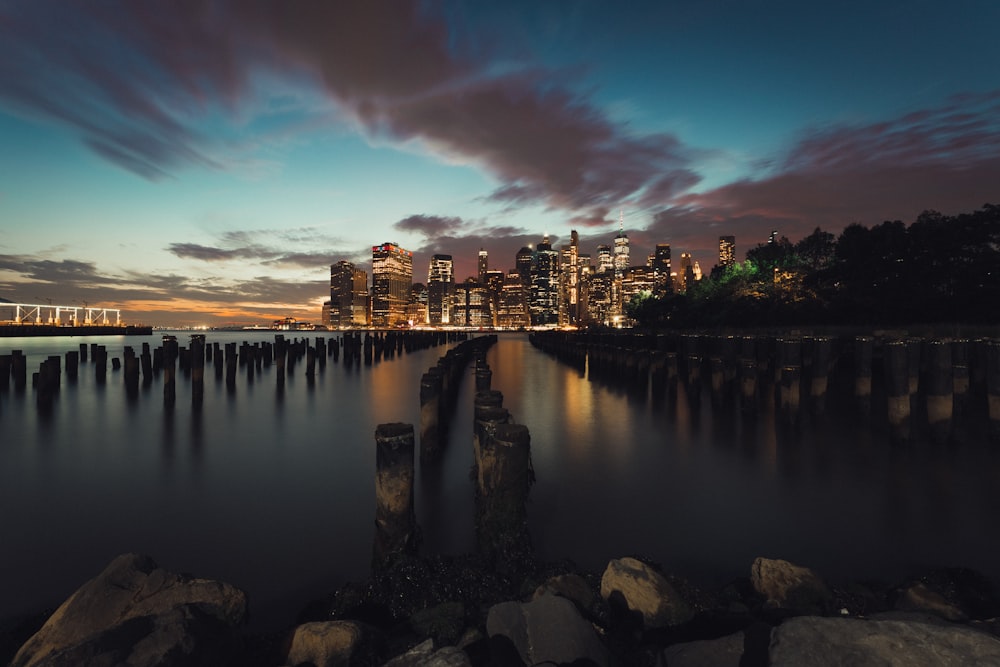 city skyline across body of water during night time