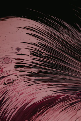 Close-up of glossy epoxy resin being poured over a wooden surface, capturing the vibrant swirl of colors.