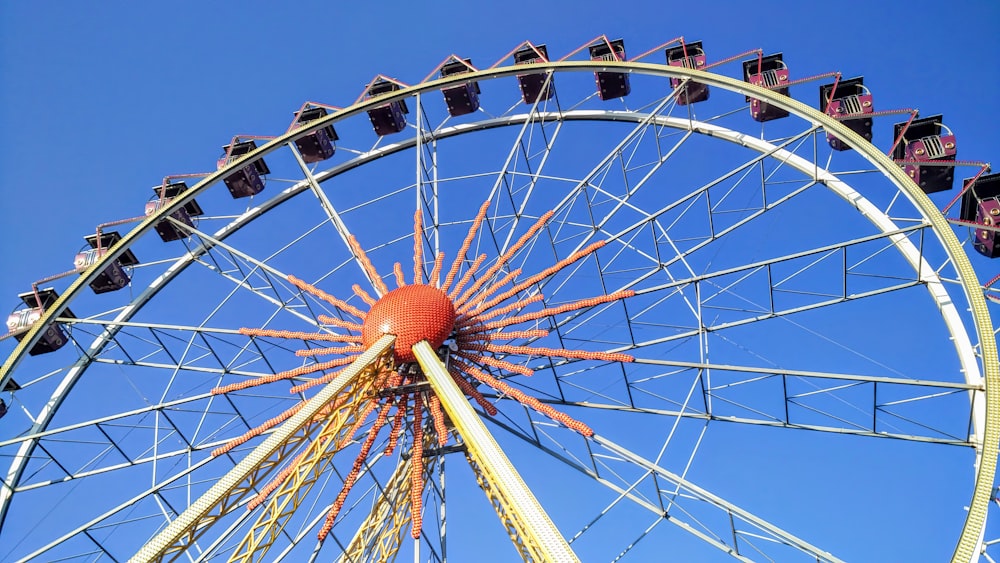 white and orange ferris wheel under blue sky during daytime