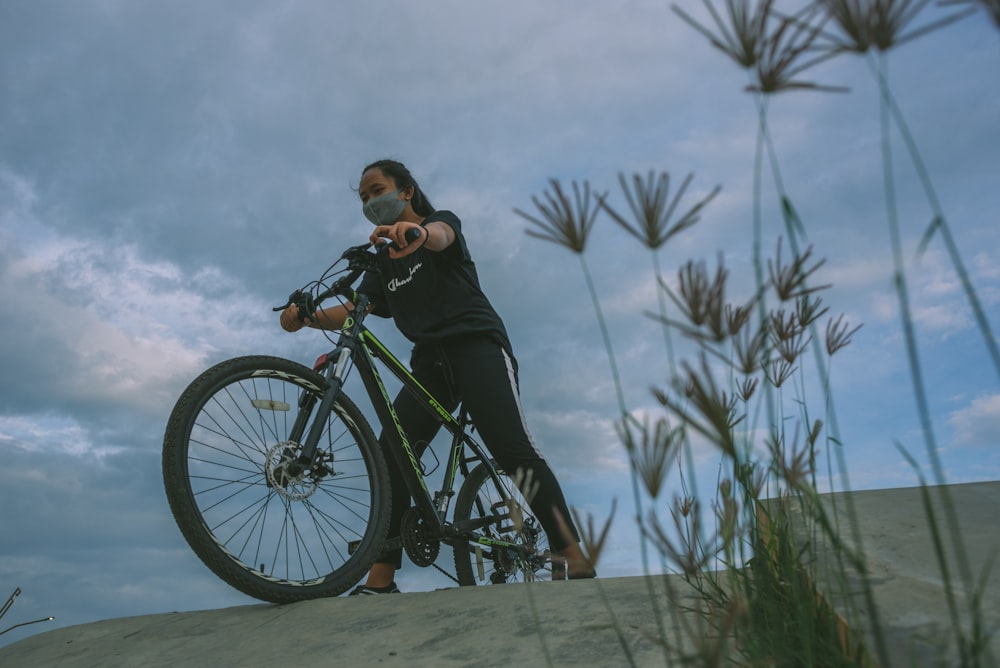 man in black jacket and black pants riding on black bicycle