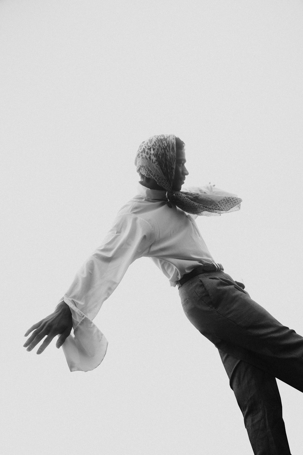 grayscale photo of man in white dress shirt and black pants