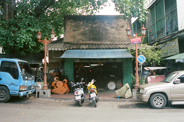Photo of the tvirtas kelias team standing outside their longtime workshop, with trucks and equipment visible in the background.