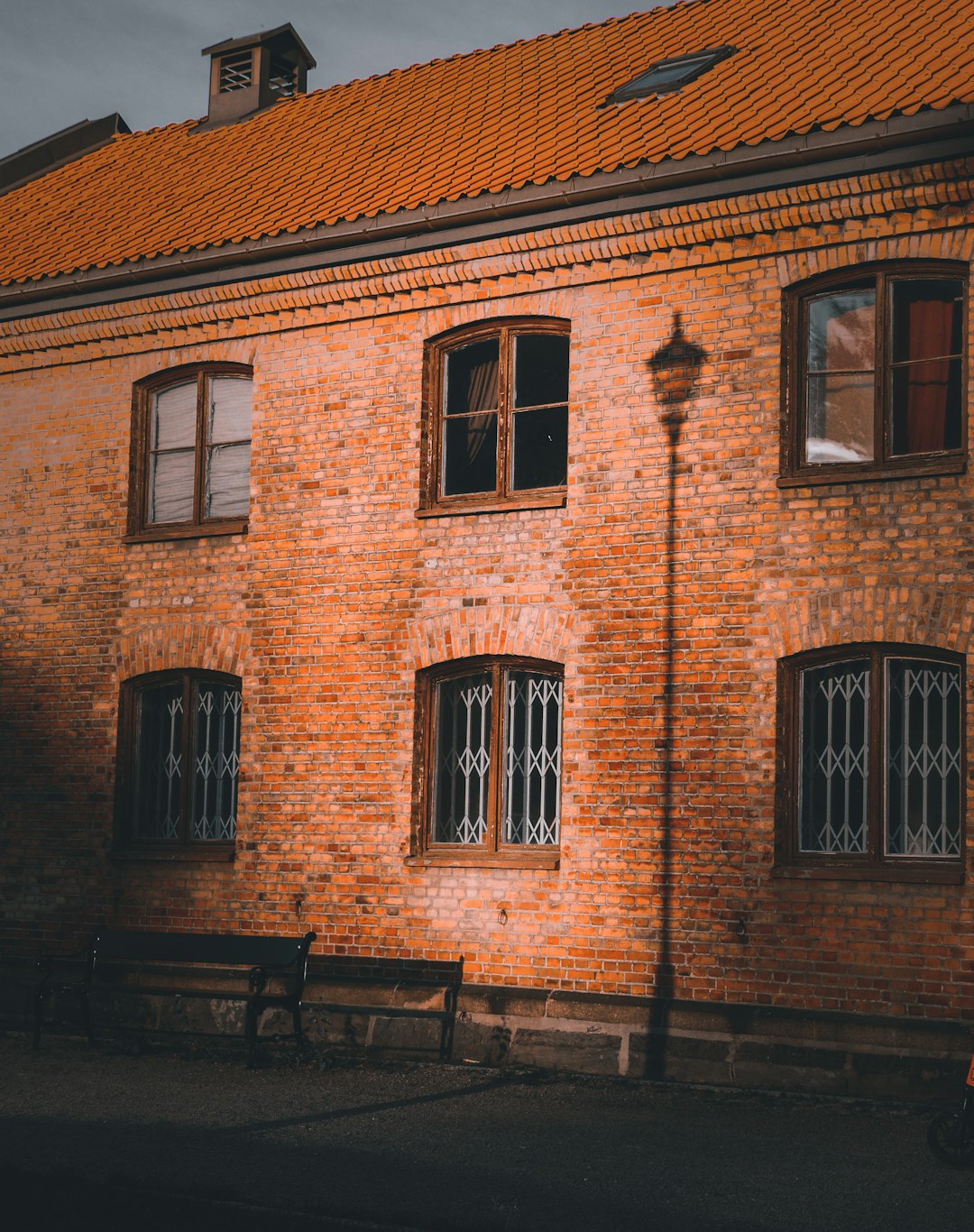 brown brick building with brown wooden bench