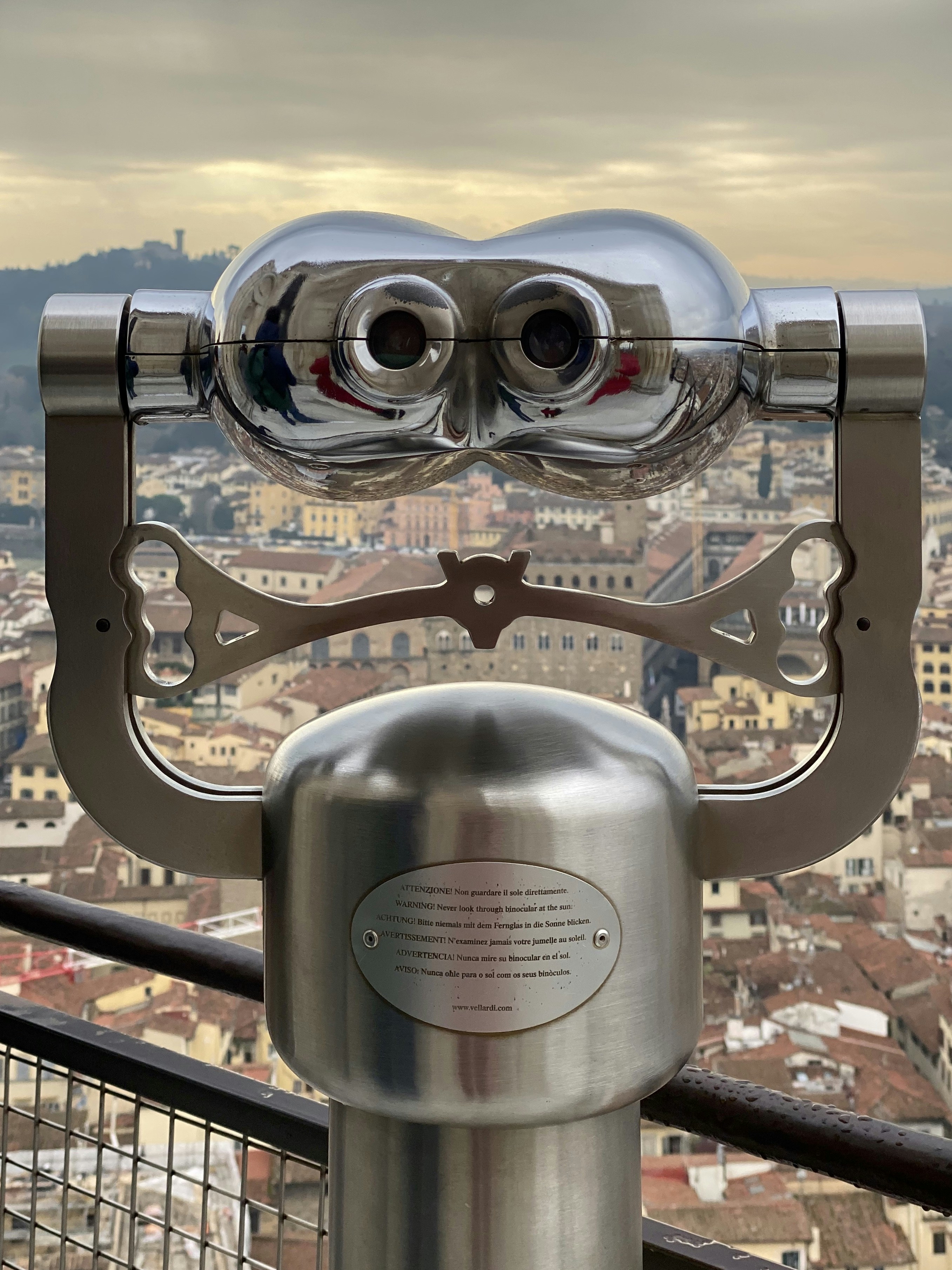 gray and black binoculars on brown metal railings