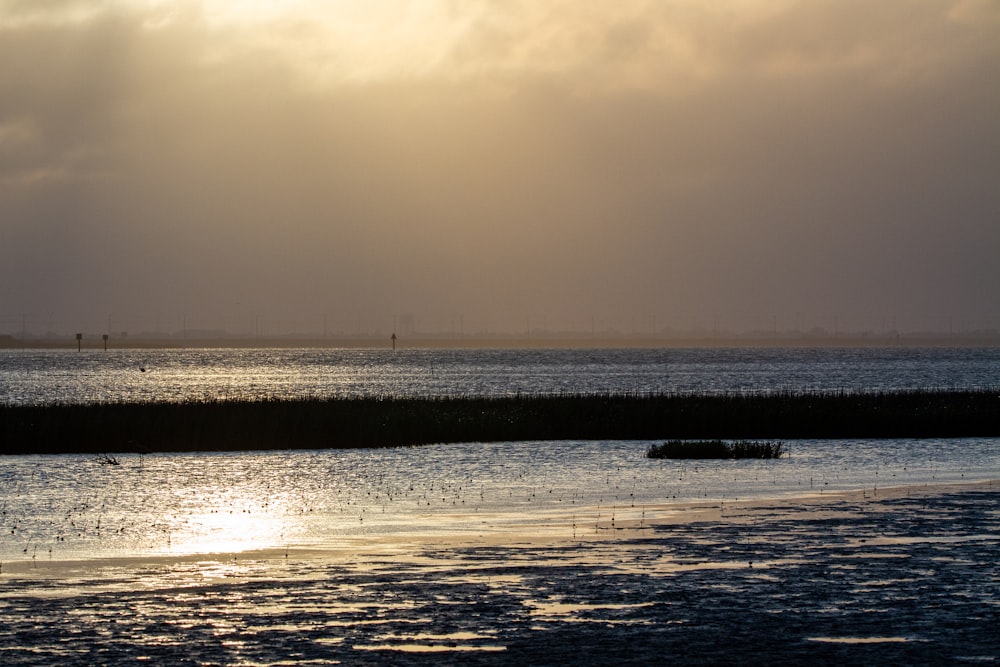 body of water under cloudy sky during daytime