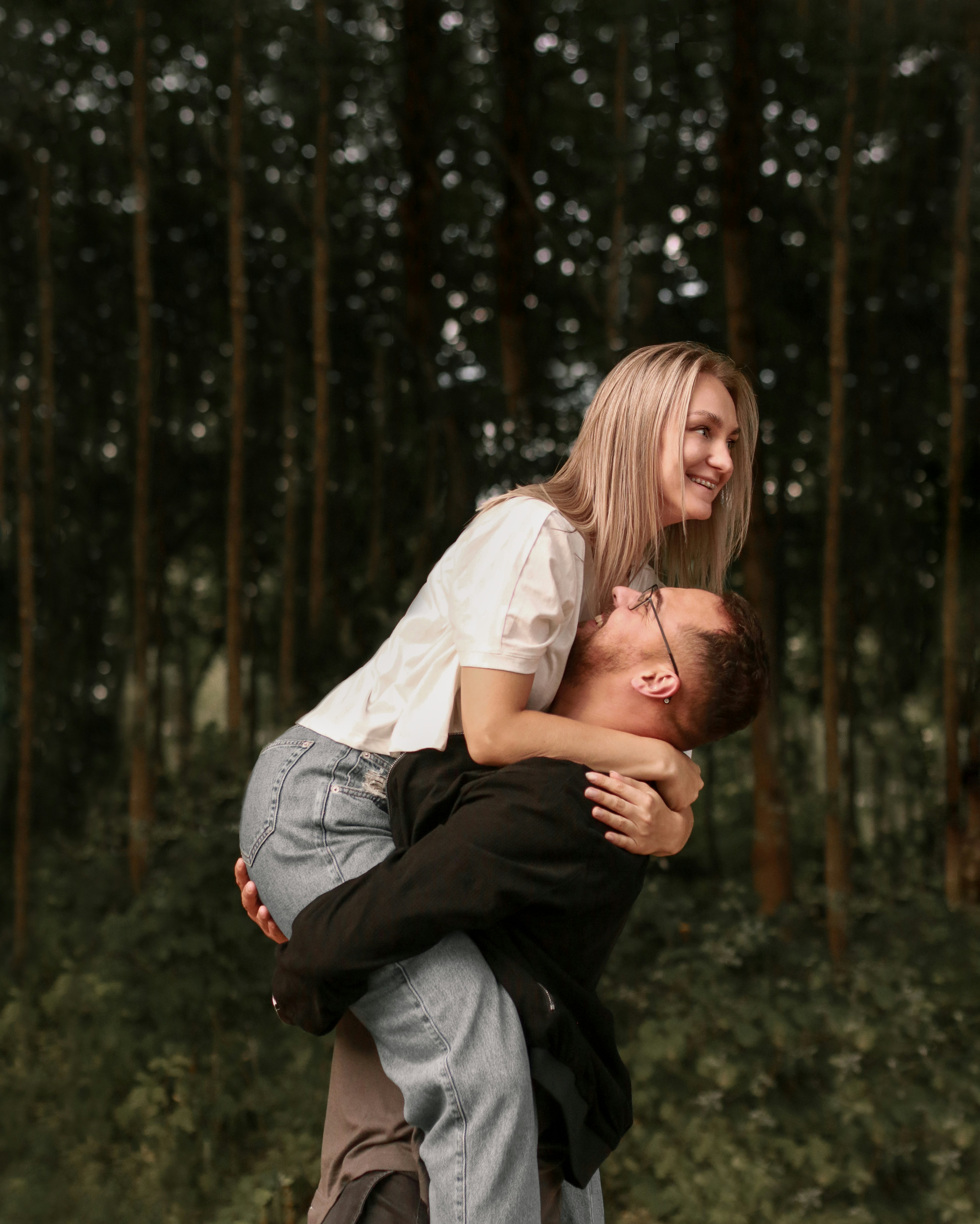 woman in white dress shirt hugging man in black pants