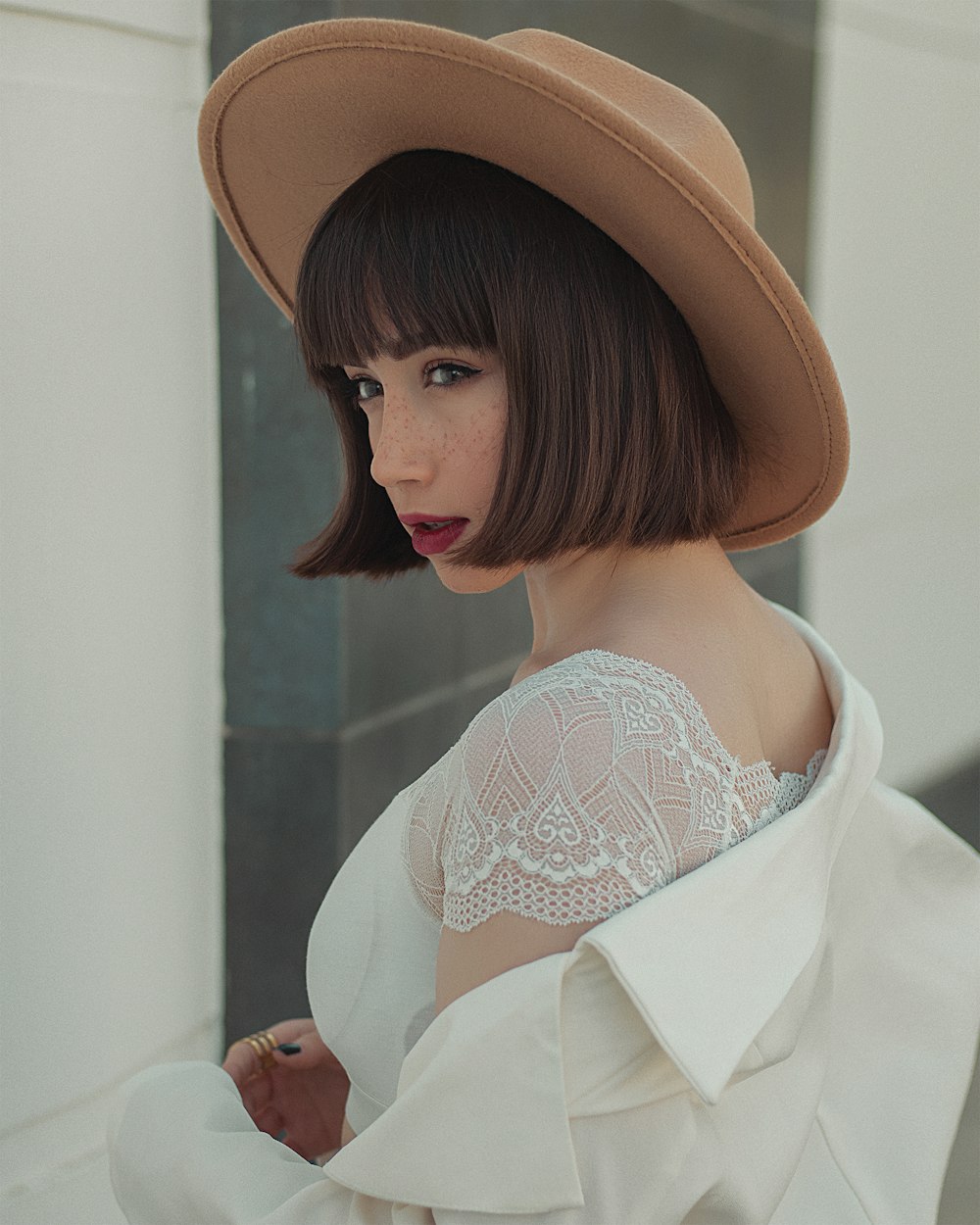 woman in white lace top wearing brown hat