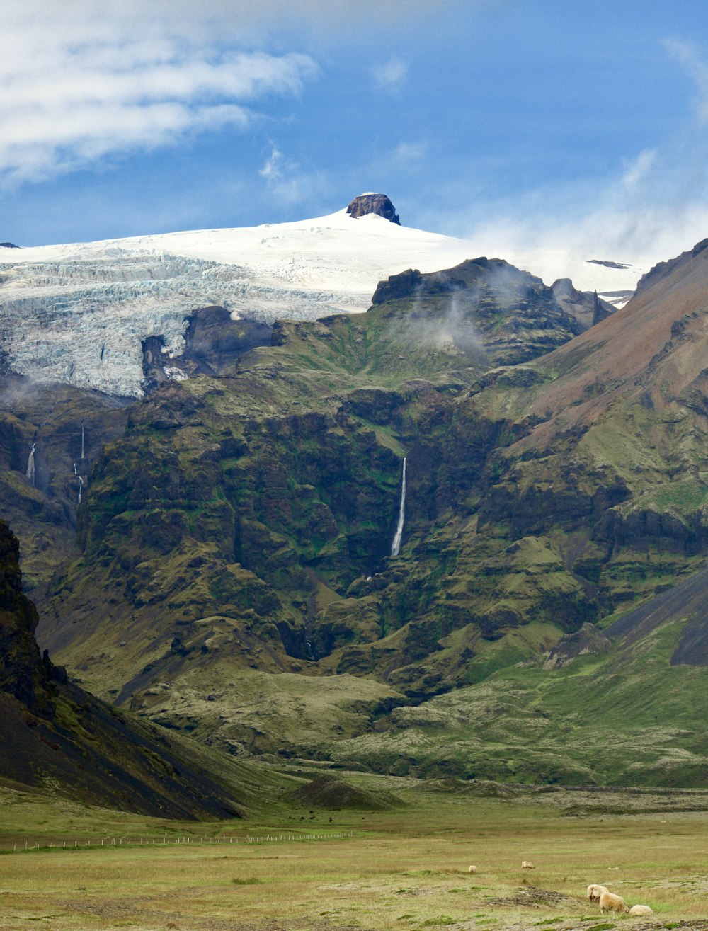 green and white mountain under white clouds during daytime