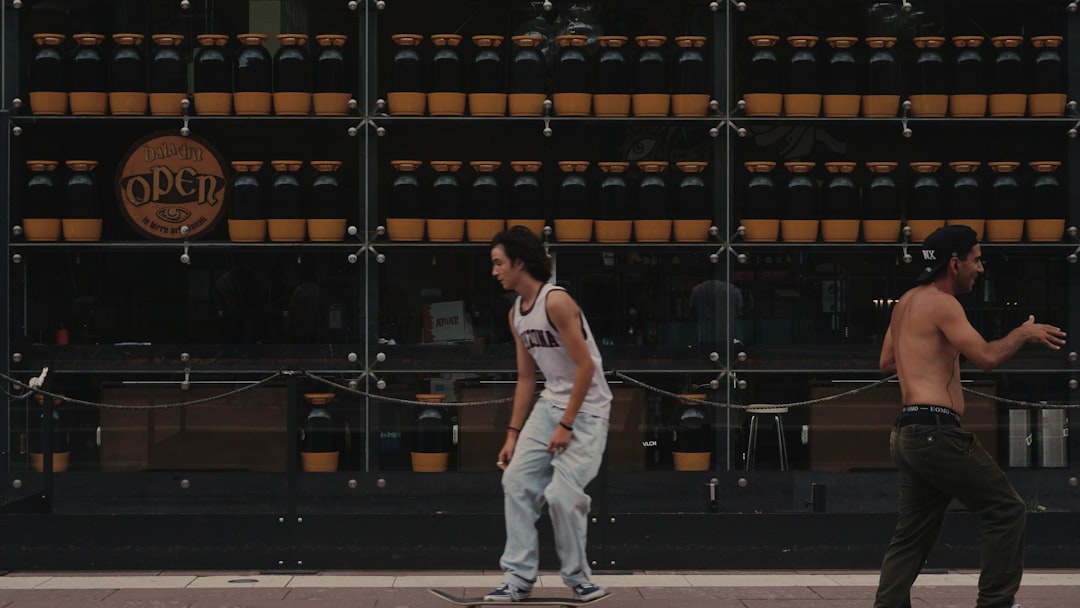 man in white tank top and white pants standing on gray concrete floor