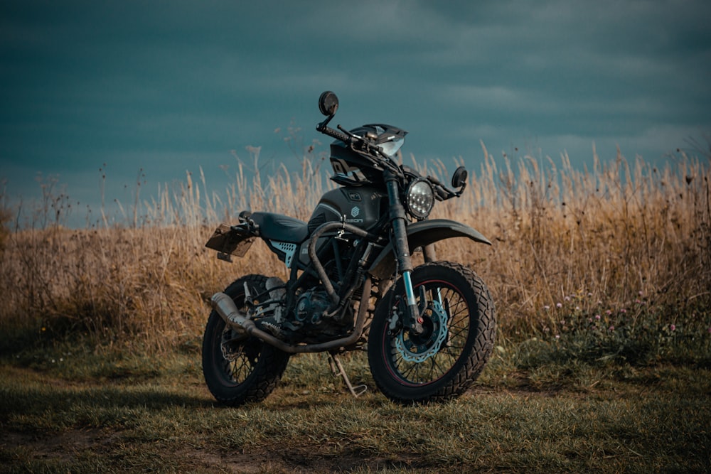 black and gray motorcycle on brown grass field under blue sky during daytime