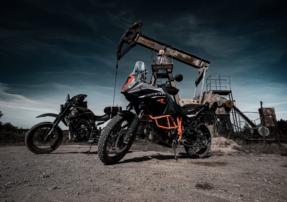 black and red naked motorcycle parked near brown wooden house during daytime