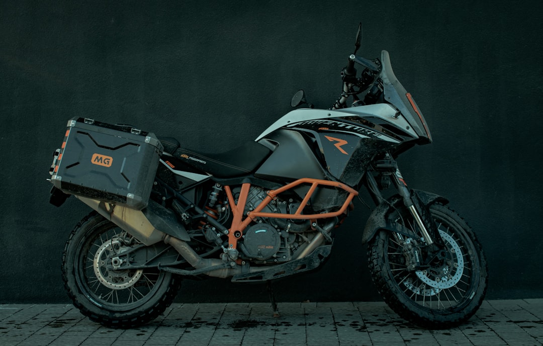 black and orange motorcycle parked on gray concrete floor
