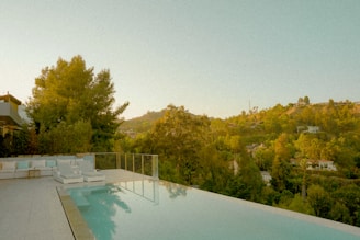 a large swimming pool surrounded by lush green trees